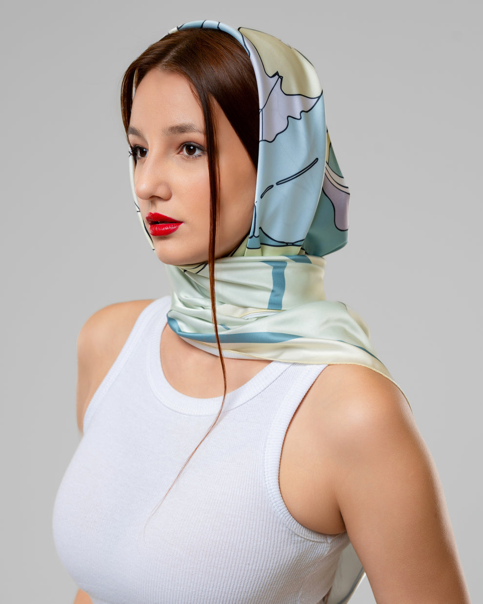 FIG SCARF IN LIGHT GREEN light green fig scarf worn elegantly by a model with a stylish look and bold red lips.